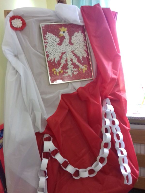 Dekoracja: biało- czerwona flaga, na niej godło Polski wykonane przez uczniów SPP oraz biało-    czerwony łańcuch