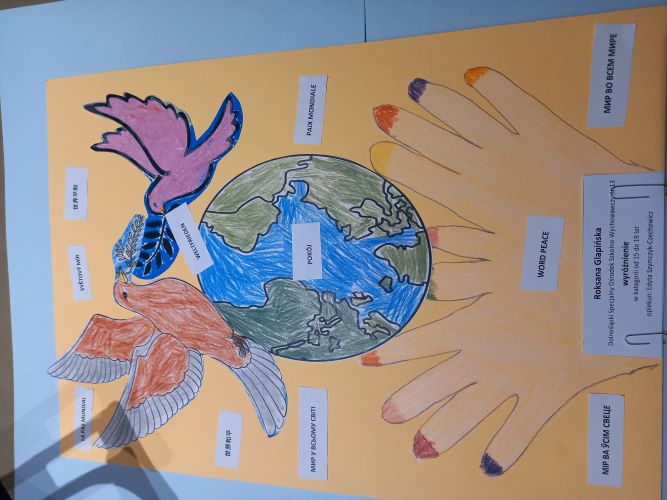 Praca Roksany: w dłoniach globus, nad nim dwa gołębie. Na całej pracy napis pokój w różnych językach