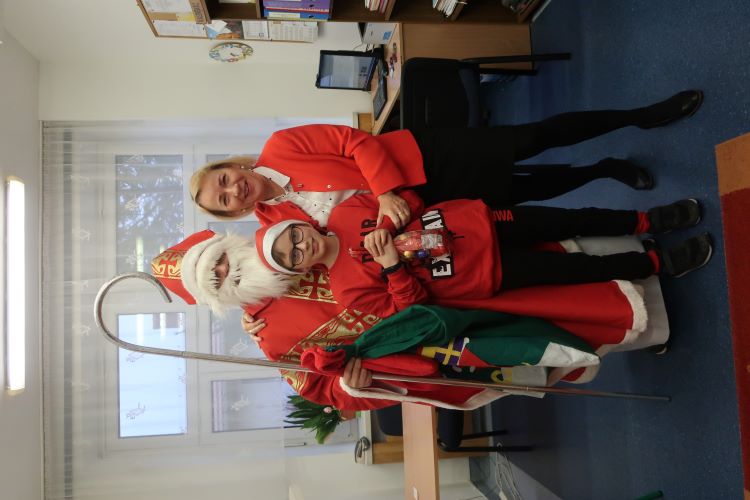 Mikołaj z Panią Dyrektor i z uczniem IV klasy - wszyscy ubrani w czerwone stroje