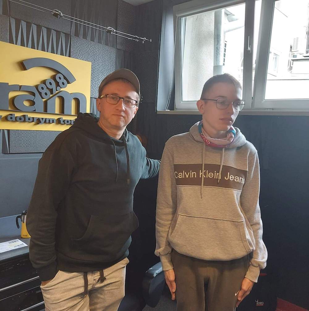 Marcel i pan Paweł Gołębski pozują na tle logo radia RAM