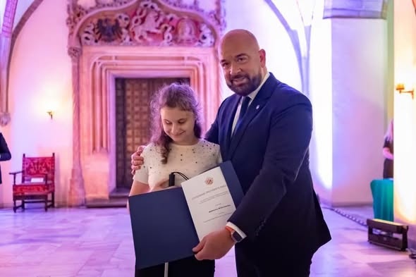 Wiktoria z prezydentem J. Sutrykiem prezentuje dyplom stypendialny